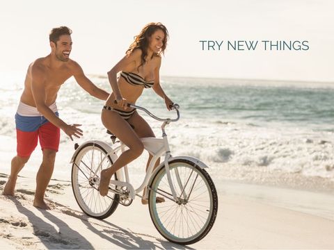 Joyful couple enjoying bicycle ride by the seaside