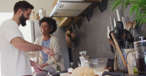 Happy couple enjoying time cooking breakfast together in kitchen