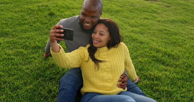 Couple taking selfie with mobile phone in the park. Smiling happy couple 4k