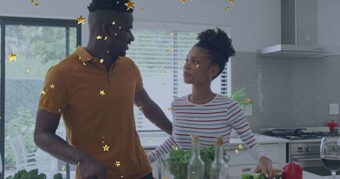 Black couple talking and cooking together at modern minimalist kitchen island with produce