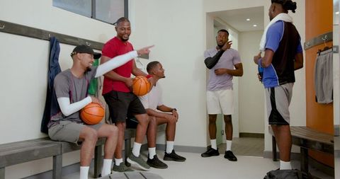 African american basketball team discussing strategy and camaraderie in locker room