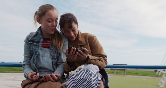 Teenage Girls Laughing Together While Watching Phone Outdoors - Download Free Stock Images Pikwizard.com