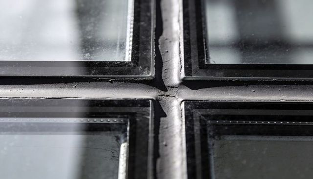 Detailing cross mullion with cracked sealant on weathered glass curtain wall panel