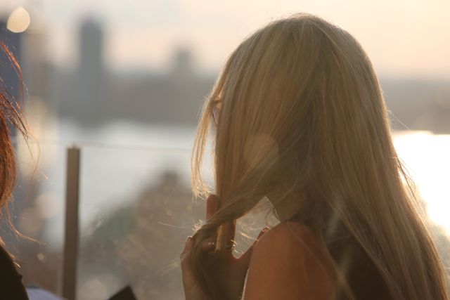 Woman Touching Long Blonde Hair in Soft Sunset Light - Download Free Stock Photos Pikwizard.com