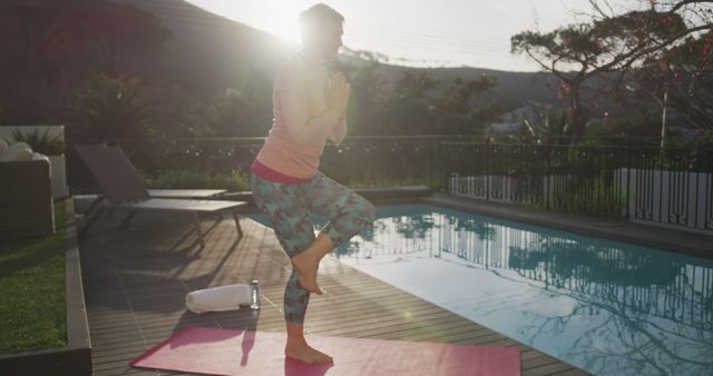 Woman practicing yoga at sunrise by swimming pool - Download Free Stock Images Pikwizard.com