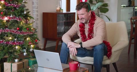 Festive Man Video Conferencing in Holiday Decorated Room