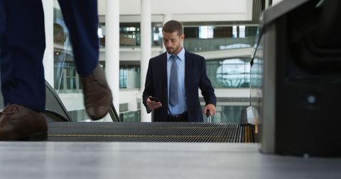Businessman Checking Phone on Office Building Escalator - Download Free Stock Images Pikwizard.com