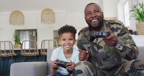Joyful Father and Son Bond Over Video Games at Home