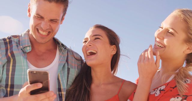 Friends Laughing Together While Looking at Smartphone Outdoors - Download Free Stock Images Pikwizard.com