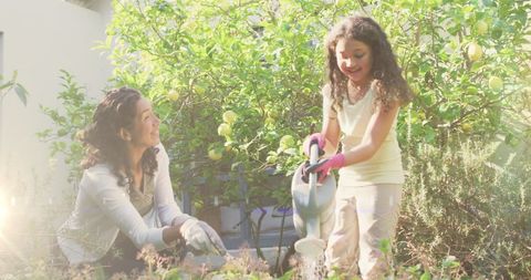 Mother and Daughter Joyfully Gardening in Backyard with Sunshine