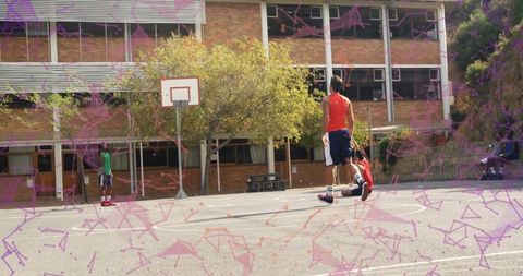 Teen students playing basketball on school court with hoop