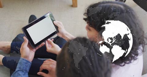 Couple sharing tablet on couch, collaborating with dotted globe overlay showing global connectivity