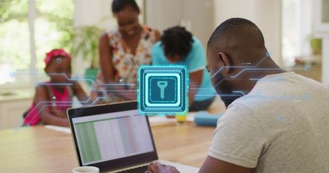 Father working on laptop at kitchen table with glowing key icon for home office security