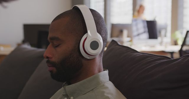 Man Relaxing with Headphones in Modern Office Environment - Download Free Stock Images Pikwizard.com