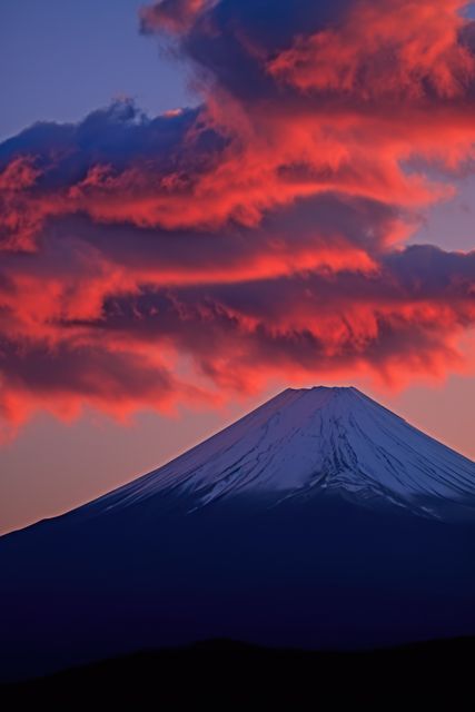 Mount Fuji under glowing red clouds at sunset, creating a dramatic and picturesque view. Ideal for travel and tourism promotions, striking backgrounds, nature and landscape blogs, and inspirational posters or calendars.