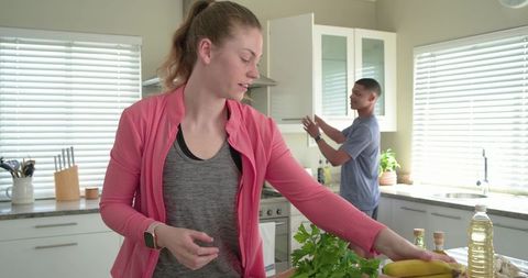 Couple preparing healthy meal in modern kitchen with fresh produce and bright daylight
