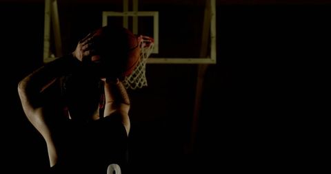 Determined Young Man Shooting Basketball in Dimly Lit Gym - Download Free Stock Images Pikwizard.com