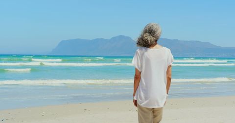 Senior Woman Enjoying Peaceful Ocean View on Serene Beach - Download Free Stock Images Pikwizard.com