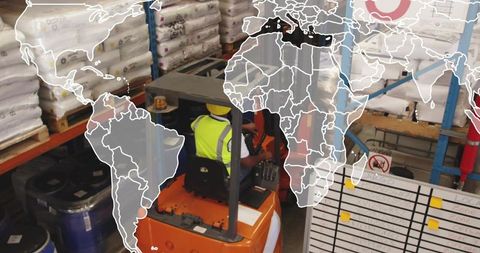 Forklift operator navigating busy warehouse wearing high-visibility vest and hard hat