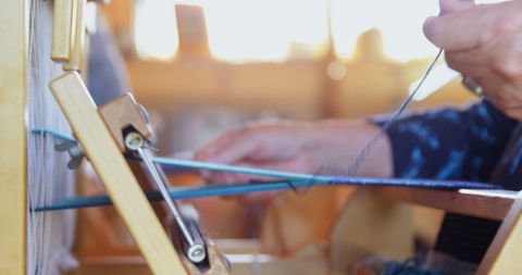 Senior Woman Weaving Cloth on Handloom in Artisans' Workshop