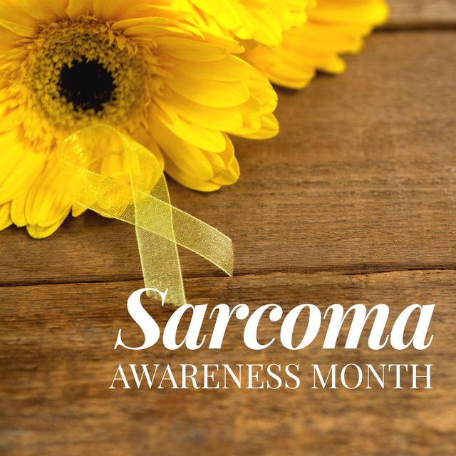 Sarcoma awareness month text in white over yellow flowers and cancer ribbon on wood. Cancerous tumor health awareness support campaign.