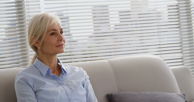 Senior Woman Sitting on Sofa in Modern Office Lounge - Download Free Stock Images Pikwizard.com