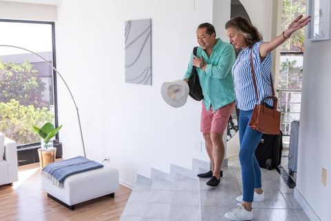 Senior Couple Arriving Home After Vacation with Luggage