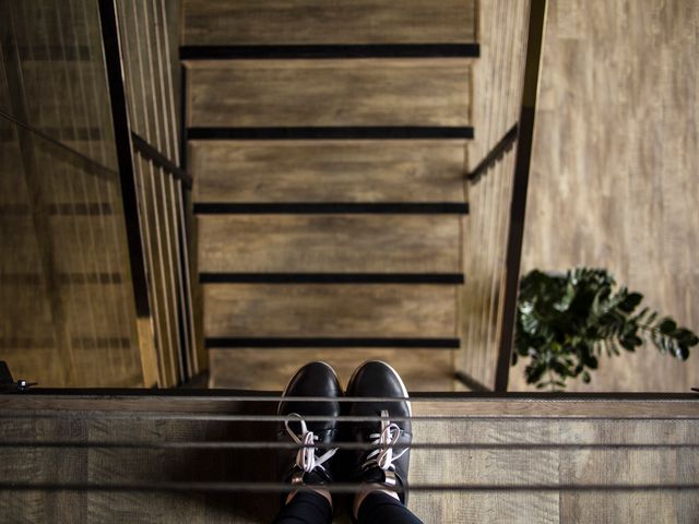 A person wearing black shoes stands at the top of a wooden staircase, with the view looking directly down the stairs. This can be used to convey perspective, architectural design, interior decor, and the feeling of anticipation. Suitable for illustrating concepts of movement, decision-making, or transition in blogs, articles, or advertisements.