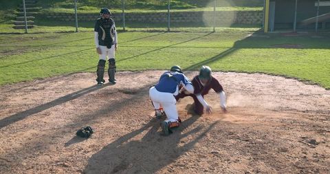 Intense Home Plate Battle as Players Slide and Tag in Sunlit Baseball Game