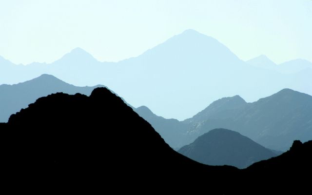 Silhouetted outline of a tranquil mountain range with varying peaks and shades. This image can be used for promoting outdoor activities, travel experiences, nature presentations, and environmental campaigns. Ideal for backgrounds, posters, and inspirational social media content.