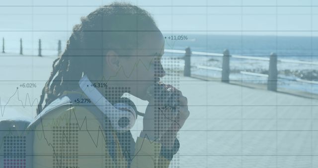 Contemplative Young Professional with Financial Graph Overlay by Seaside - Download Free Stock Images Pikwizard.com