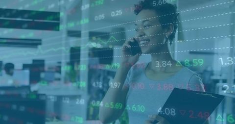 Businesswoman talking on phone while holding clipboard with overlaid stock market charts