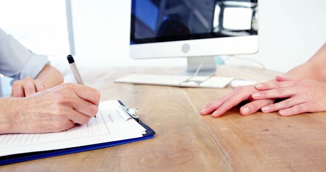 Professional Meeting at Wooden Desk with Computer in Background - Download Free Stock Images Pikwizard.com