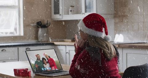 Woman in Santa Hat Having Virtual Family Christmas Call with Snow Effect
