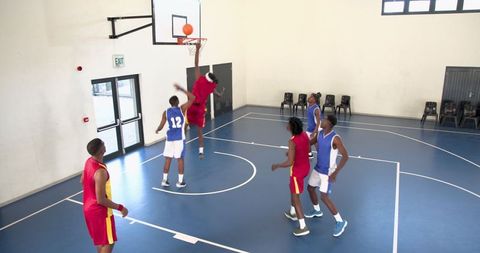 Athletic Dunk Action During Basketball Game in Indoor Court