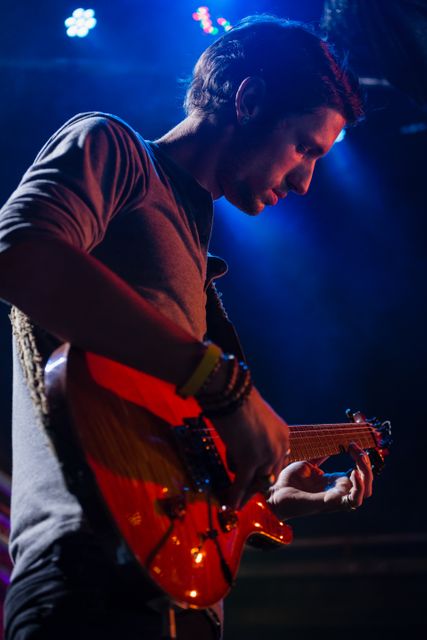 Guitarist playing guitar on stage in nightclub