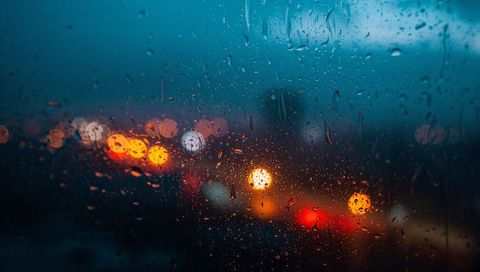 Raindrops on windshield with blurred tail lights moody urban night bokeh rain streaks