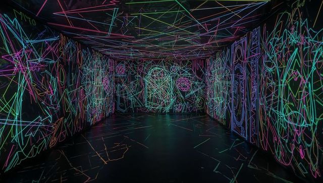 Neon line labyrinth filling dark gallery with immersive multicolor light installation