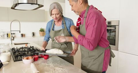 Senior Couple Baking Bread Together in Modern Kitchen