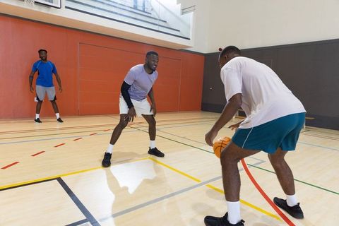 African american men playing basketball in indoor gym defensive drill and dribbling action