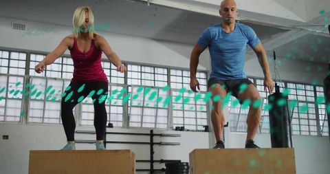 Dynamic fitness partners jumping on plyometric boxes
