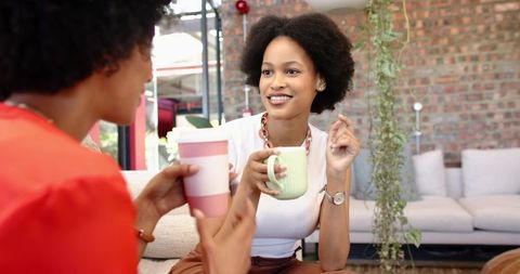 Female friends relaxing and chatting in cozy lounge