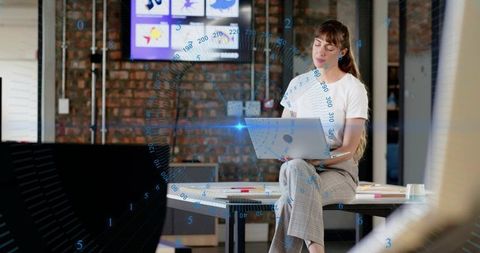 Young professional using laptop with augmented reality overlay in modern coworking loft
