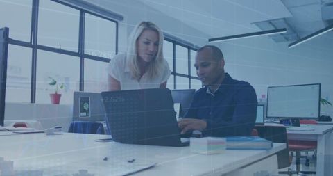 Colleagues Collaborating on Laptop with Digital Financial Overlay