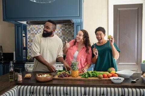 Diverse Friends Preparing Fresh Fruit in Modern Kitchen