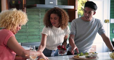 Diverse Friends Joyfully Preparing Meal in Cozy Kitchen