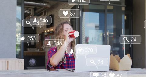 Young man engaging online social media on laptop outdoors