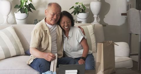 Senior Couple Embracing and Smiling Joyfully on Sofa
