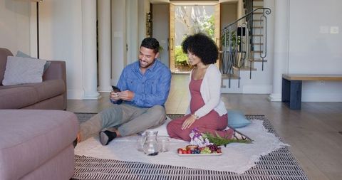 Diverse Couple Enjoying Indoor Picnic on Cozy Blanket