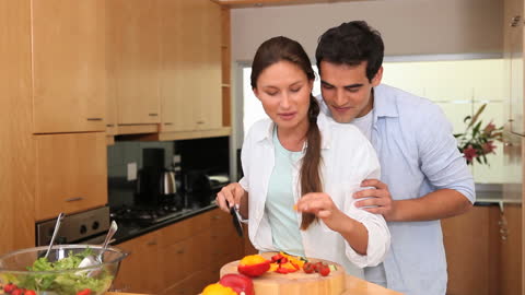 Couple Embracing in Modern Kitchen While Cooking Together